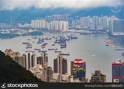 Aerial view of group of boats in sea near Victoria Harbour with skyscraper buildings in Hong Kong. Financial district in urban city, Downtown for travel and transportation background.