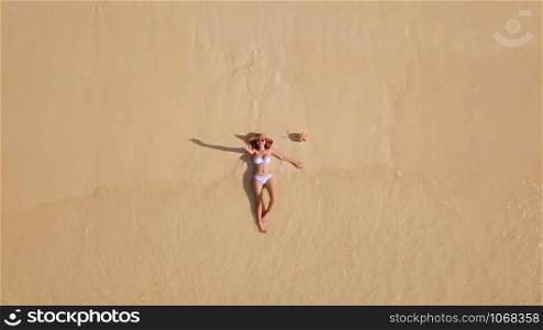 Aerial view of happy Asian woman, a sexy Thai lady, relaxing and enjoying at turquoise sea near Phuket beach in summer during travel holidays vacation trip outdoor at natural ocean or island, Thailand