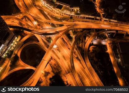 Aerial view of highway junctions at night. Bridges, roads, or streets in transportation concept. Structure shapes of architecture in urban city, Kuala Lumpur Downtown, Malaysia. Top view