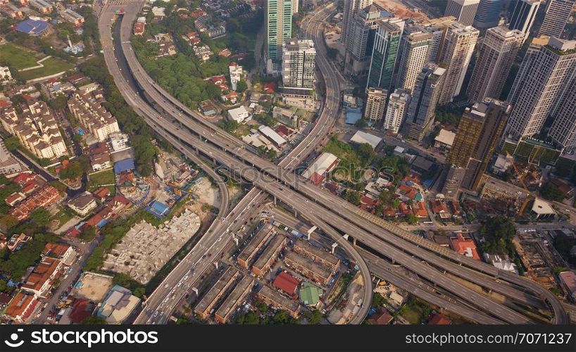 Aerial view of highway junctions at sunset. Bridges, roads, or streets in transportation concept. Structure shapes of architecture in urban city, Kuala Lumpur Downtown, Malaysia. Top view