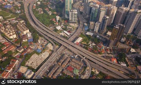 Aerial view of highway junctions at sunset. Bridges, roads, or streets in transportation concept. Structure shapes of architecture in urban city, Kuala Lumpur Downtown, Malaysia. Top view