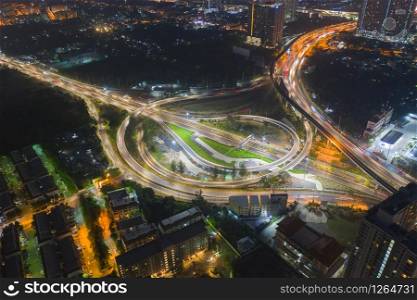 Aerial view of highway junctions. Bridge roads shape circle in structure of transportation concept. Top view. Urban city, Bangkok at night, Thailand. Architecture landscape background.