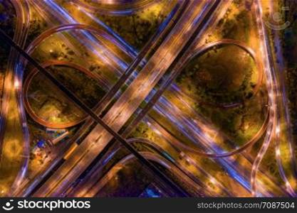 Aerial view of highway junctions. Bridge roads shape number 8 or infinity sign in structure of architecture concept. Top view. Urban city, Bangkok at night, Thailand.