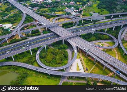 Aerial view of highway junctions. Bridge roads shape number 8 or infinity sign with green garden and trees in connection of architecture concept. Top view. Urban city, Taipei at sunset, Taiwan.