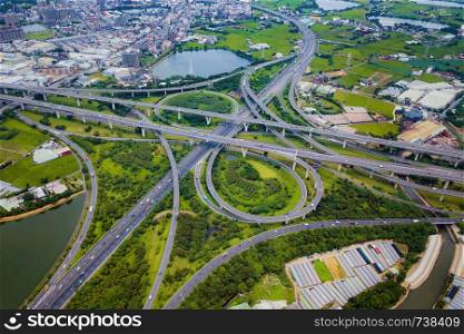 Aerial view of highway junctions. Bridge roads shape number 8 or infinity sign with green garden and trees in connection of architecture concept. Top view. Urban city, Taipei at sunset, Taiwan.