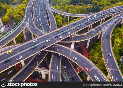 Aerial view of highway junctions shape letter x cross. Bridges, roads, or streets with trees in transportation concept. Structure shapes of architecture in urban city, Shanghai Downtown, China.