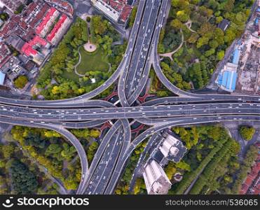 Aerial view of highway junctions shape letter x cross. Bridges, roads, or streets with trees in transportation concept. Structure shapes of architecture in urban city, Shanghai Downtown, China.