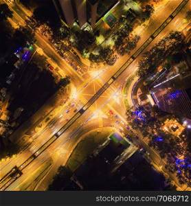Aerial view of highway junctions shape letter x cross at night. Bridges, roads, or streets in transportation concept. Structure shapes of architecture in urban city, Kuala Lumpur Downtown, Malaysia