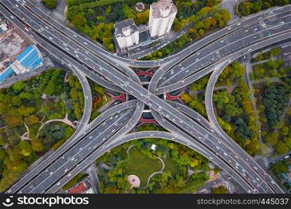 Aerial view of highway junctions shape letter x cross at noon. Bridges, roads, or streets in transportation concept. Structure shapes of architecture in urban city, Shanghai Downtown, China.