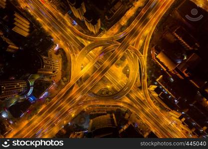 Aerial view of highway junctions with roundabout. Bridge roads shape circle in structure of architecture and transportation concept. Top view. Urban city, Shanghai at night, China.
