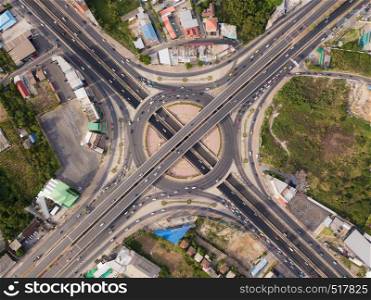 Aerial view of highway junctions with roundabout. Bridge roads shape circle in structure of architecture and transportation concept. Top view. Urban city, Bangkok at sunset, Thailand.