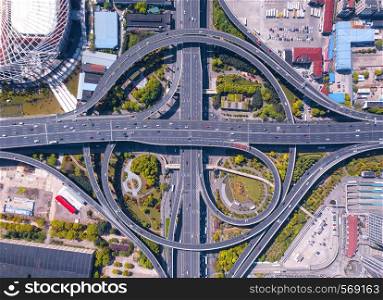Aerial view of highway junctions with roundabout. Bridge roads shape circle in structure of architecture and transportation concept. Top view. Urban city, Shanghai, China.