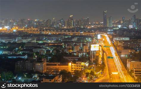 Aerial view of highway steet roads in Bangkok Downtown skyline, Thailand. Financial business district and residential area in smart urban city. Skyscraper and high-rise buildings at night time.