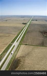 Aerial view of highway through rural farmland with crops.