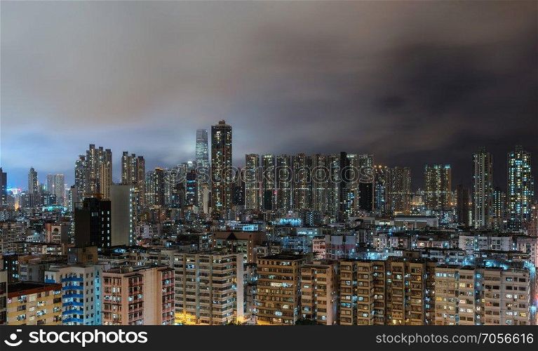 Aerial view of Hong Kong apartments in cityscape background. Residential district in smart city in Asia. Buildings at night.