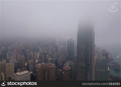 Aerial view of Hong Kong Downtown and Victoria Harbour with rain storm and fog. Financial district and business centers in smart city and technology concept. skyscraper and high-rise office buildings
