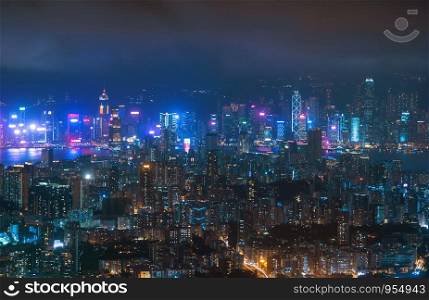 Aerial view of Hong Kong Downtown, Republic of China. Financial district and business centers in technology smart city in Asia. Top view of skyscraper and high-rise buildings at night.