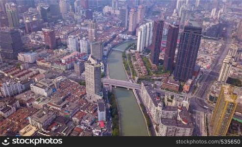 Aerial view of Huangpu River in Shanghai Downtown, China. Financial district and business centers in smart city in Asia. Top view of skyscraper and high-rise office buildings at sunset.