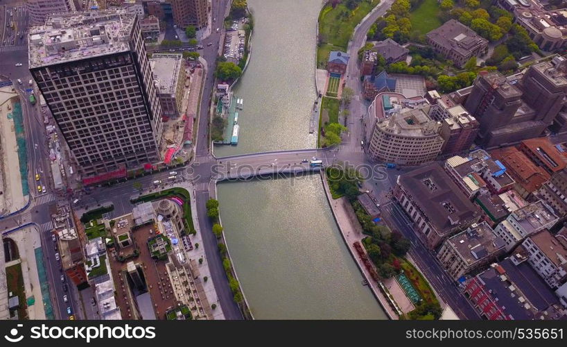 Aerial view of Huangpu River in Shanghai Downtown, China. Financial district and business centers in smart city in Asia. Top view of skyscraper and high-rise office buildings at sunset.