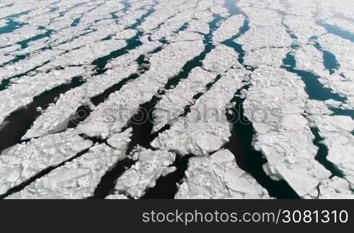Aerial view of ice on the sea with sunlight. Pack contains 3 clip