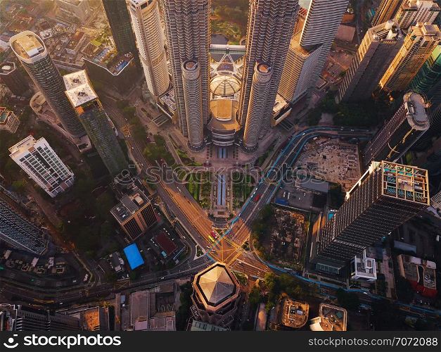 Aerial view of intersection in Kuala Lumpur Downtown, Malaysia. Financial district and business centers in smart urban city in Asia. Skyscraper and high-rise buildings at sunset.