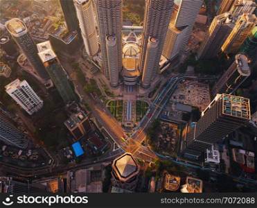 Aerial view of intersection in Kuala Lumpur Downtown, Malaysia. Financial district and business centers in smart urban city in Asia. Skyscraper and high-rise buildings at sunset.