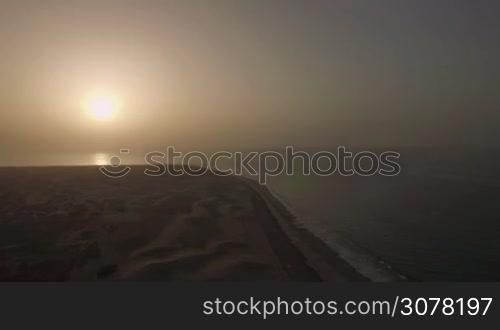 Aerial view of island coastline and vast sand dunes during the sunset over the ocean. Gran Canaria, Canary Islands