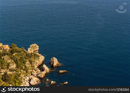 Aerial view of Isola Bella's island and beach on blue ocean water in Taormina - Sicily.