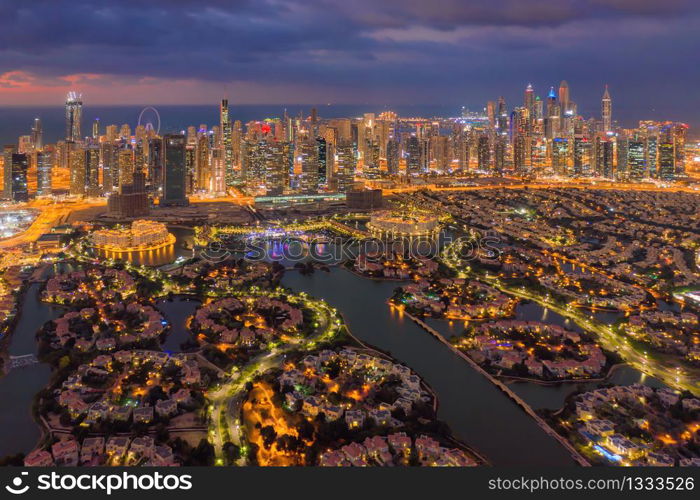 Aerial view of Jumeirah island, Dubai Downtown skyline in United Arab Emirates or UAE. Financial district and business area in smart urban city. Skyscraper and high-rise buildings at night.