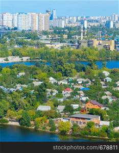 Aerial view of Kiev cityscape with modern residential district of high-rises and private housing area on green peninsula at Dnieper river