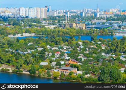 Aerial view of Kiev cityscape with modern residential district of high-rises and private housing area on green peninsula at Dnieper river
