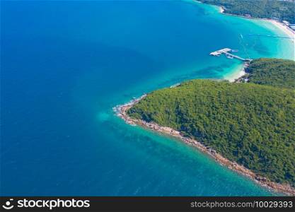 Aerial view of Koh Larn beach, Pattaya with blue turquoise seawater, mountain hills, and tropical green forest trees with Andaman sea in island in summer, Thailand in travel trip. Nature background.