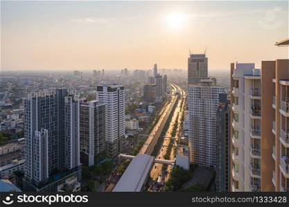 Aerial view of Krung ThonBuri street road in Bangkok Downtown skyline, Thailand. Financial business district and residential area in smart urban city. Skyscraper and high-rise buildings at sunset.