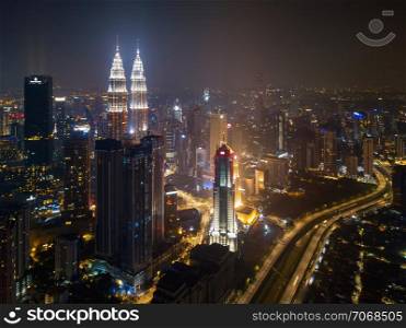 Aerial view of Kuala Lumpur Downtown and highways, Malaysia. Financial district and business centers in smart urban city in Asia. Skyscraper and high-rise buildings at night.