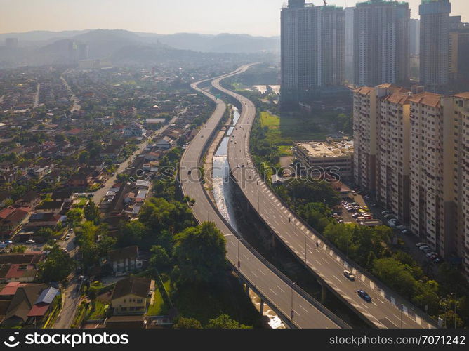 Aerial view of Kuala Lumpur Downtown, Malaysia and highways road. Financial district and business centers in smart urban city in Asia. Skyscraper and high-rise buildings at noon with blue sky.