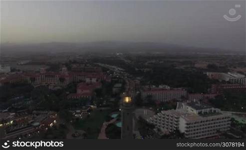 Aerial view of lit Maspalomas Lighthouse and tourist resort in the dusk, Gran Canaria