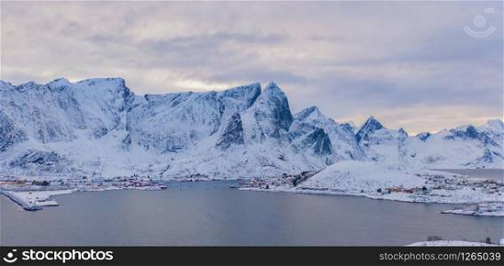 Aerial view of Lofoten islands and lake or river, Nordland county, Norway, Europe. White snowy mountain hills and trees, nature landscape background in winter season. Famous tourist attraction.