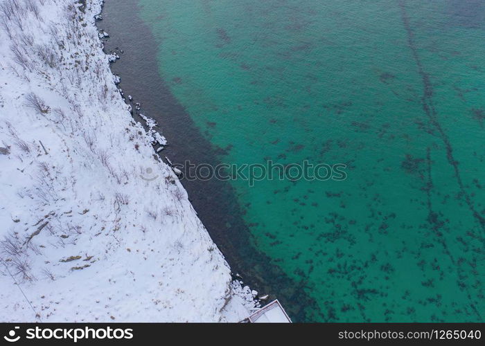 Aerial view of Lofoten islands and lake or river, Nordland county, Norway, Europe. White snowy mountain hills and trees, nature landscape background in winter season. Famous tourist attraction.