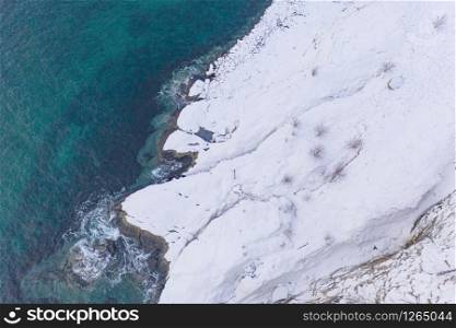 Aerial view of Lofoten islands and lake or river, Nordland county, Norway, Europe. White snowy mountain hills and trees, nature landscape background in winter season. Famous tourist attraction.