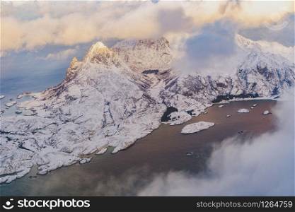 Aerial view of Lofoten islands, Nordland county, Norway, Europe. White snowy mountain hills and trees, nature landscape background in winter season. Famous tourist attraction