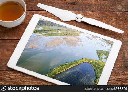 aerial view of lower Niobrara River in Nebraska Sandhills, reviewing image on a digital tablet