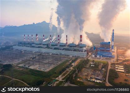 Aerial view of Mae Moh Coal Power Plant with smoke and toxic air from chimney. Factory industry. Electricity tower in energy or pollution environment concept. Lampang City, Thailand
