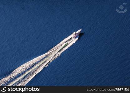 Aerial view of man wakeboarding on lake. Water skiing on lake behind a boat.