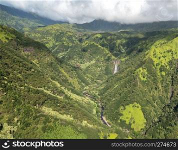 Aerial view of Manawaiopuna Falls and landscape of hawaiian island of Kauai from helicopter flight. Garden Island of Kauai from helicopter tour