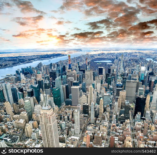 Aerial view of Manhattan skyline from the sky on a cloudy day, New York City at sunset.