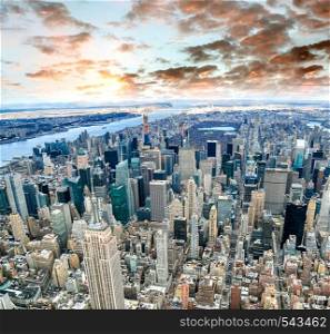 Aerial view of Manhattan skyline from the sky on a cloudy day, New York City at sunset.
