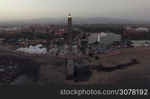 Aerial view of Maspalomas Lighthouse and resort area in the evening. Flying from the coast over the ocean, Gran Canaria