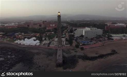 Aerial view of Maspalomas Lighthouse and resort area in the evening. Flying from the coast over the ocean, Gran Canaria