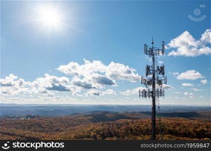 Aerial view of mobile phone cell tower over forested rural area of West Virginia to illustrate lack of broadband internet service. Cell phone or mobile service tower in forested area of West Virginia providing broadband service