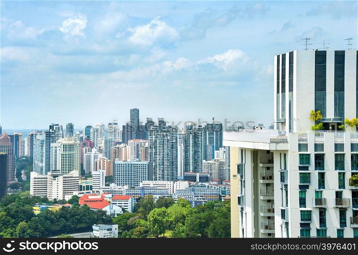 Aerial view of modern residential city district, skyline with green trees under overcast sky with clouds, Singapore